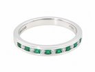 an  eternity ring featuring a channel setting of round-cut green emeralds and clear diamonds. The inner band is engraved with 'M390' and 'PT950'.