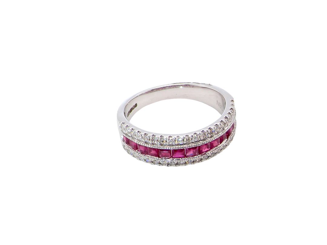 top view An 18 carat white gold half hoop ring. A triple row design with a line of channel set calibre cut rubies running along the centre , to a total carat weight of 0.97 carats.
