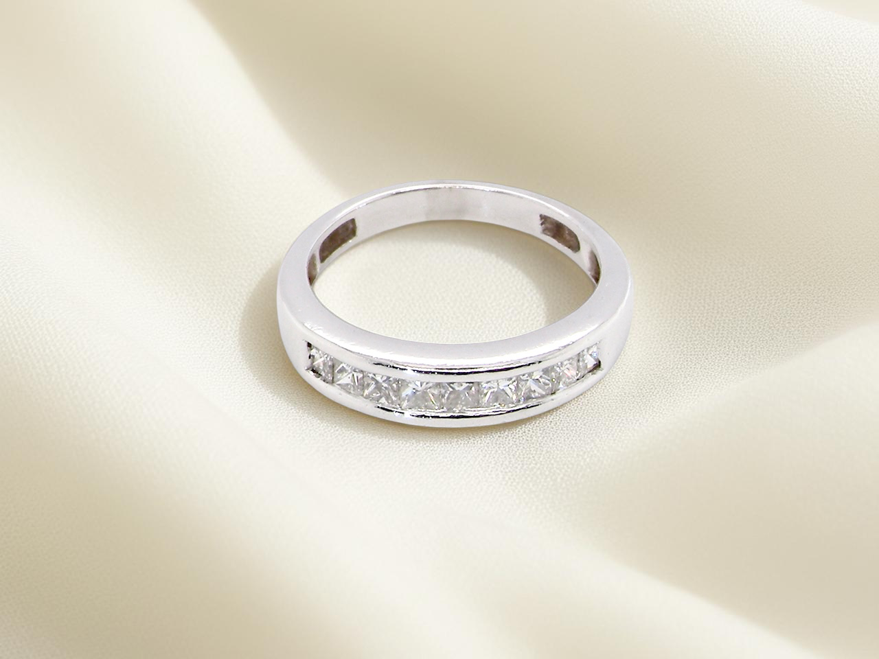 top view An elegant half-hoop eternity ring set with nine princess-cut white diamonds, each measuring approximately 2.5mm, with a total estimated diamond weight of 0.90 carats.