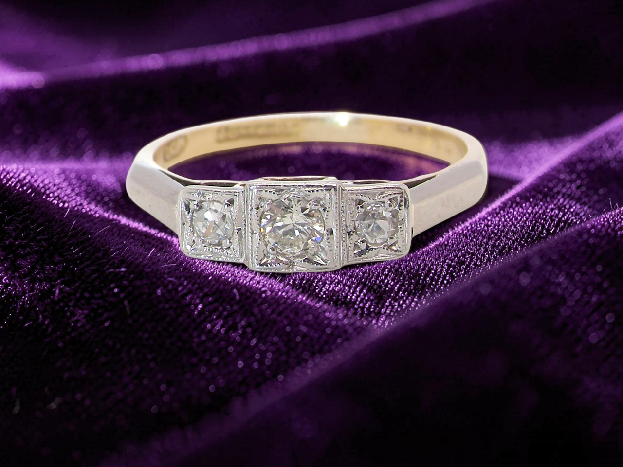 A vintage trilogy ring. Set with three old brilliant cut white diamonds, centre 3mm and each side a 2.4mm diamond. Total estimated at 0.20 carats, colour H-j, clarity Si

