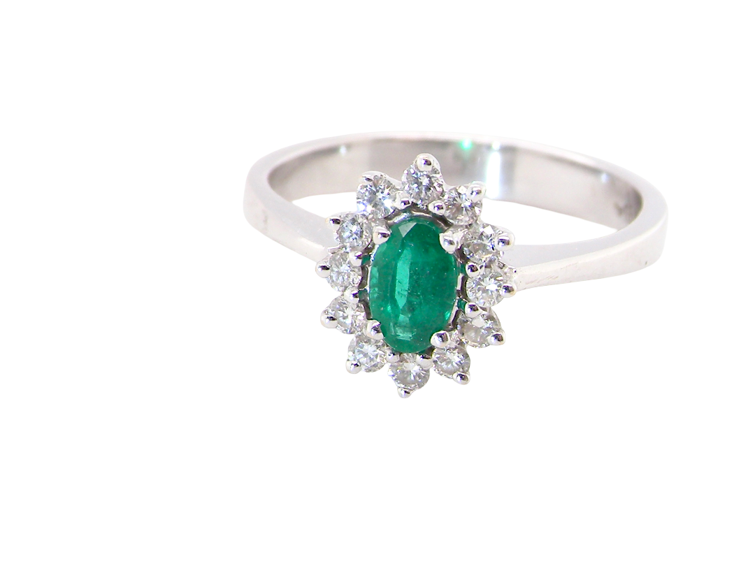 white gold cluster ring.

Centre stone is an oval cut emerald, 6x3.7mm (just under 0.50 carats) deep green hue.