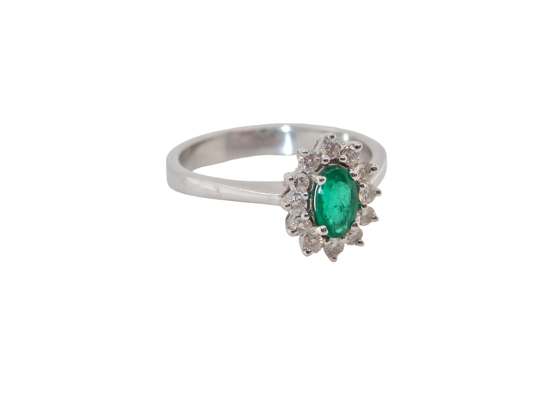 white gold cluster ring.

Centre stone is an oval cut emerald, 6x3.7mm (just under 0.50 carats) good deep green hue. side