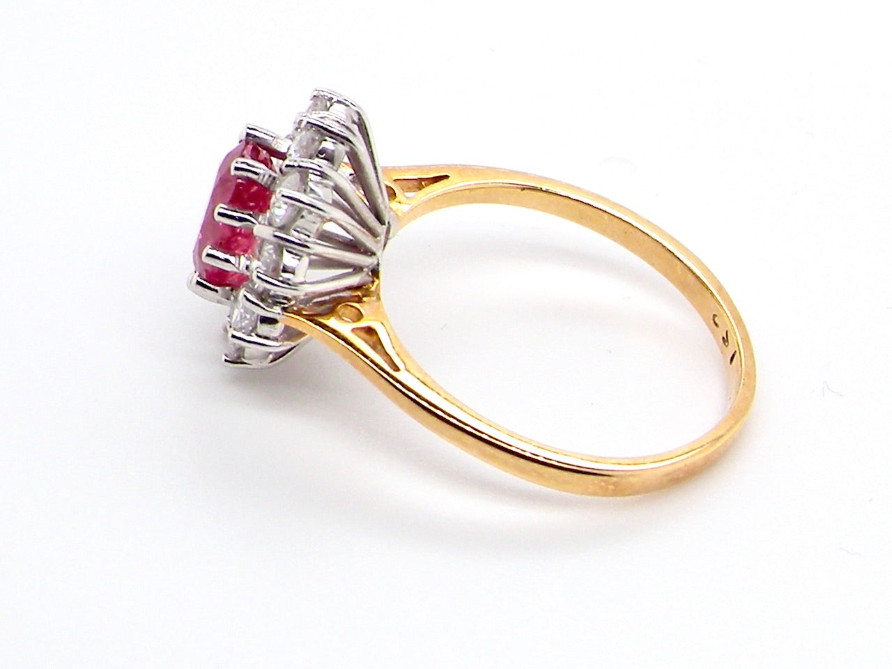 A classic cluster ring centred with an oval pinkish-red ruby measuring approximately 9 × 6 mm (estimated 1.75 carats)