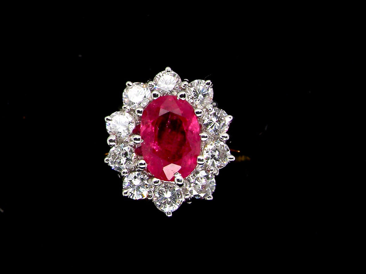 A classic cluster ring centred with an oval pinkish-red ruby measuring approximately 9 × 6 mm (estimated 1.75 carats)