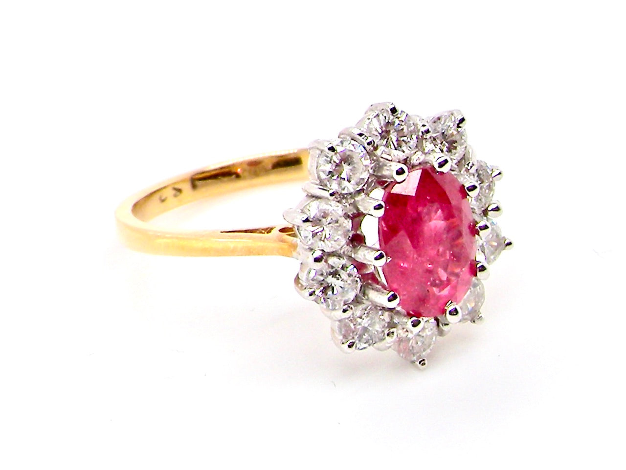 A classic cluster ring centred with an oval pinkish-red ruby measuring approximately 9 × 6 mm (estimated 1.75 carats)